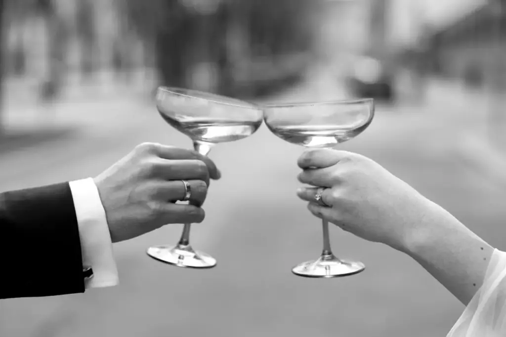 Brautpaar stoßt auf Hochzeitstag mit einem Glas Champagner in Wien an